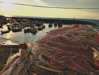 Close-up of fishing net at harbor against sky