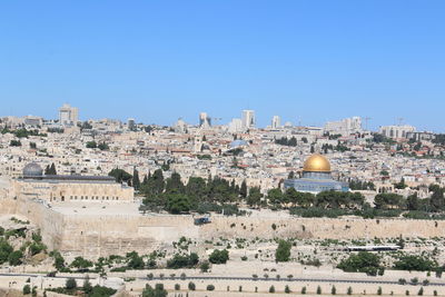 Panoramic view of buildings against clear blue sky