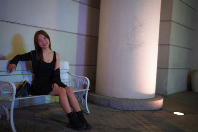 Portrait of young woman sitting on floor