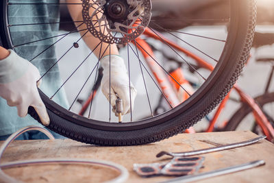 Midsection of man repairing bicycle tire on table
