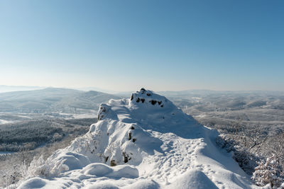 Scenic view of snowcapped mountains against clear sky during winter