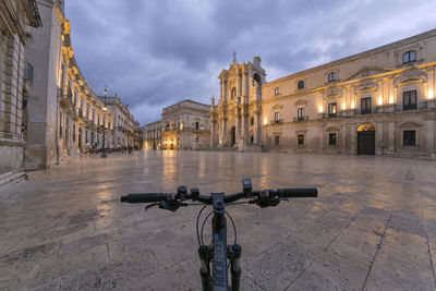 Street amidst buildings in city at dusk