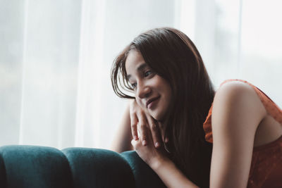 Portrait of smiling woman sitting at home