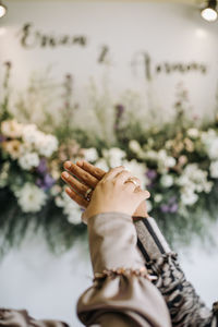 Low section of people holding flowering plants