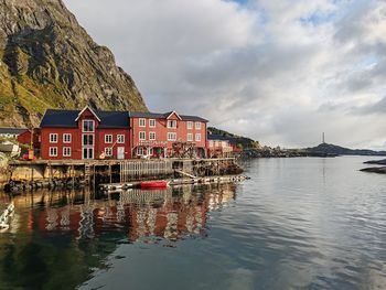 Buildings by lake against sky