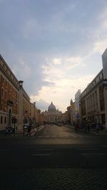 People walking on street in city against sky