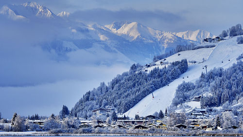 Ski lift over snowcapped mountains against sky