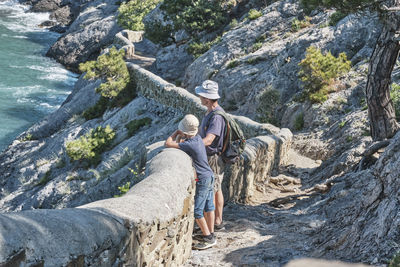 People sitting on rock by mountain