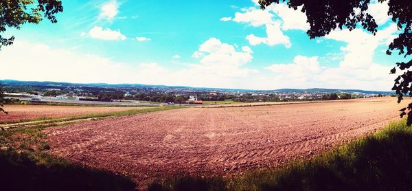 Scenic view of field against cloudy sky