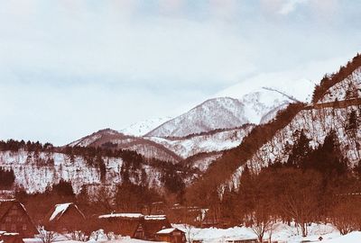 Scenic view of snow covered mountains against blue sky