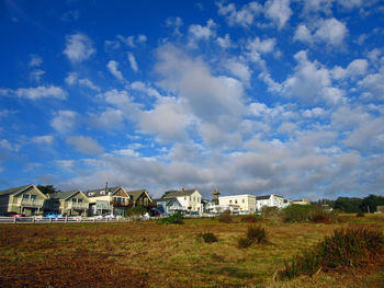 View of field against cloudy sky