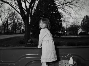 Portrait of girl standing in pick-up truck at park