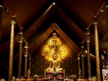 Illuminated buddha statues in building