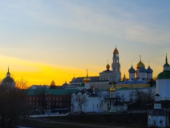 Buildings in city against sky during sunset