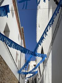 Low angle view of rope against buildings