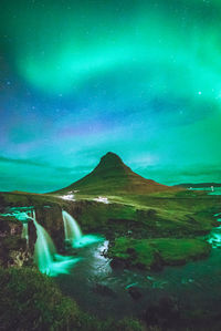 Scenic view of illuminated mountains against sky at night