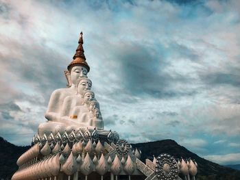 Low angle view of statue against building against sky