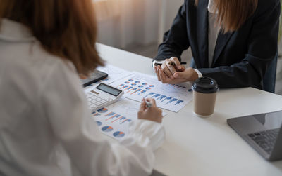 Midsection of business colleagues working at desk in office