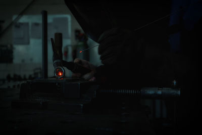 Close-up of man working on metal in factory