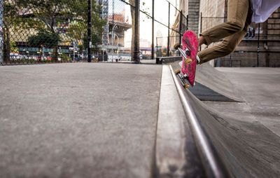 Low section of man skateboarding on street in city