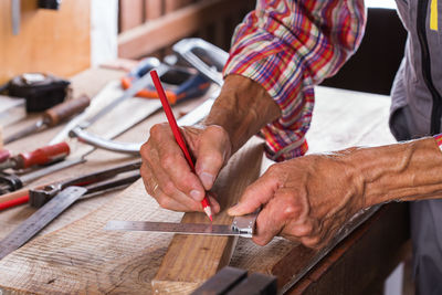 Midsection of carpenter working at workshop