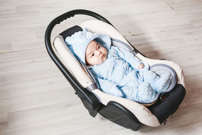 High angle view of baby lying down on hardwood floor