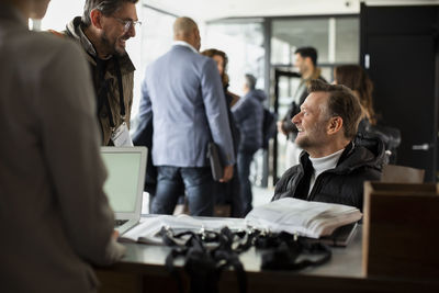 Businessman talking to disabled entrepreneur during seminar at conference center