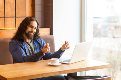 Man using laptop while sitting in cafe