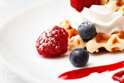 Close-up of raspberry and waffle in plate