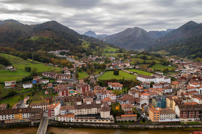 High angle view of townscape by mountains against sky