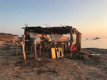 Boats at built structure against sky during sunset