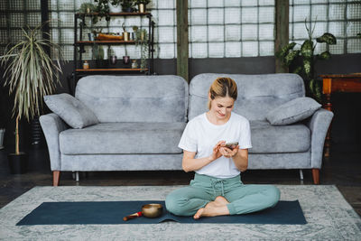 Full length of family sitting on sofa at home