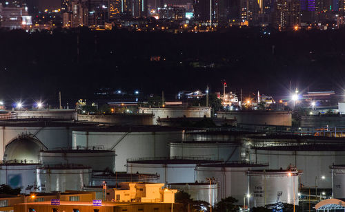 Illuminated city by buildings at night