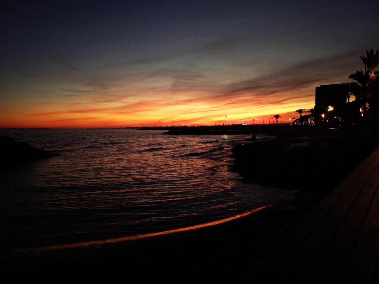 sky, water, sea, sunset, nature, beauty in nature, beach, horizon, scenics - nature, evening, tranquility, dusk, land, afterglow, cloud, tranquil scene, orange color, horizon over water, no people, ocean, reflection, silhouette, architecture, outdoors, idyllic, coast, transportation, sunlight, sun, built structure, travel destinations