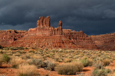 Rock formations on landscape against cloudy sky