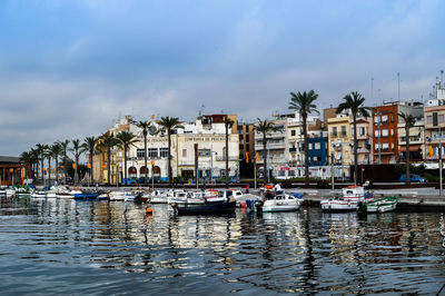 Boats in harbor with buildings in background