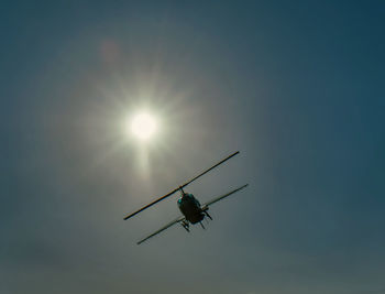 Low angle view of silhouette insect against blue sky