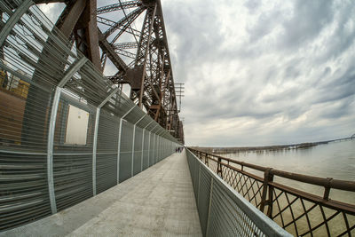 Low angle view of bridge over water against sky