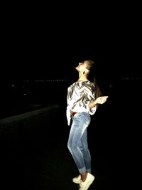 Full length of illuminated lighting equipment against black background