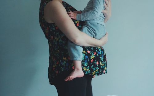 Midsection of couple standing against wall