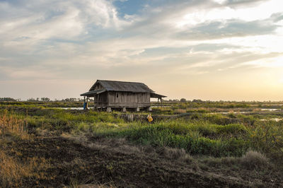 Abandoned house on field against sky