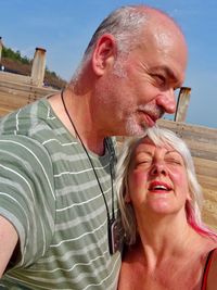 Close-up of mature couple against sky during sunny day