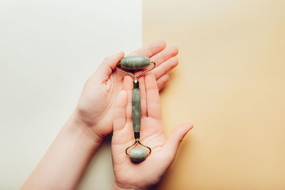 Close-up of hand holding ring over white background