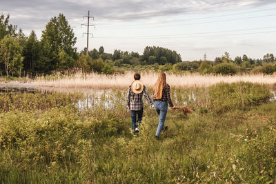 Full length of couple on field against sky