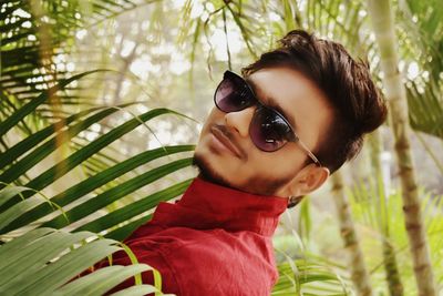 Portrait of man wearing sunglasses by trees