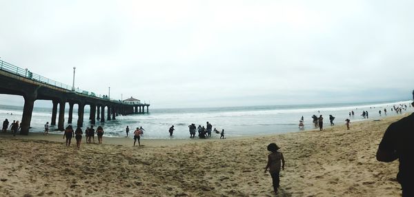 People at beach against sky