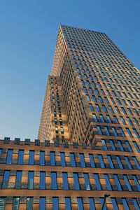 Low angle view of modern building against clear blue sky