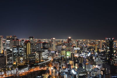 Illuminated cityscape against sky at night