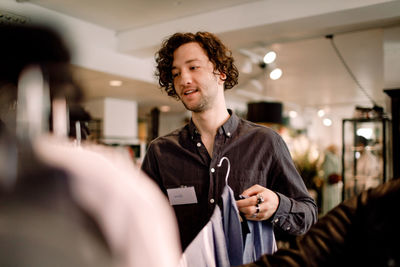 Salesman with clothes at fashion store