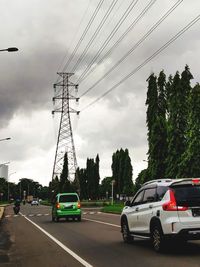 Cars on road against sky in city